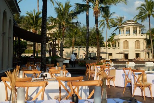 Dukade bord utomhus för att abonnera restaurang vid en pool.